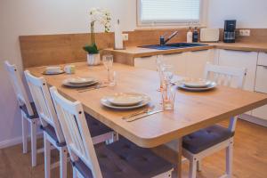 drewniany stół z płytami i okularami w kuchni w obiekcie Harzblick w mieście Sankt Andreasberg
