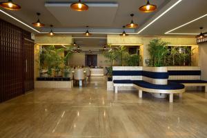 a lobby with benches and potted plants at Airport hotel deep palace near international airport in New Delhi
