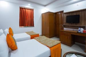 a hotel room with two beds and a television at Airport hotel deep palace near international airport in New Delhi