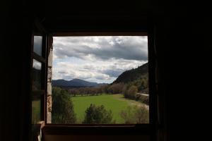 una ventana con vistas a un campo verde en Hotel & SPA Peña Montañesa, en Aínsa