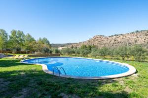 una piscina en el césped con una montaña en el fondo en Mas de Sisco, en Flix