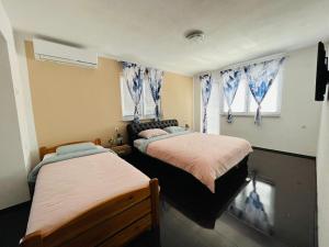 1 dormitorio con 2 camas y 2 ventanas en Summer house LejHana, en Bihać