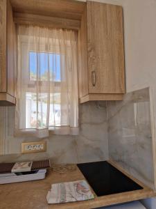 een keuken met houten kasten en een raam bij Christina Studios in Kefalos