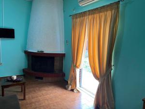 sala de estar con ventana y chimenea en Sofi's apartment, en Agios Konstantinos