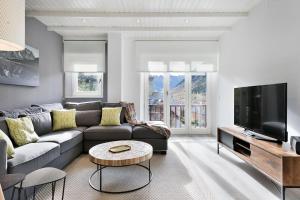 a living room with a couch and a tv at Luderna - Apartamento Cap de Aran A2 in Baqueira-Beret