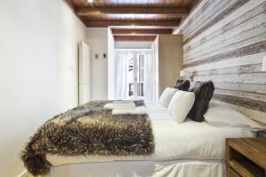 - une chambre avec un grand lit et un mur en bois dans l'établissement Luderna - Apartamento Val de Ruda A19 de Saumet, à Naut Aran