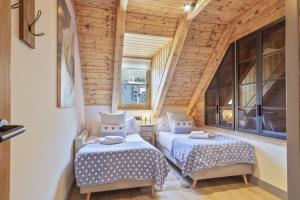 2 camas en una habitación con paredes y ventanas de madera en Luderna - Val de Ruda C23 Barbacans, en Baqueira Beret