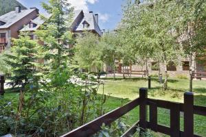 a fence in front of a yard with a house at Luderna - Apartamento Val de Ruda A61 de Sarradé in Baqueira-Beret