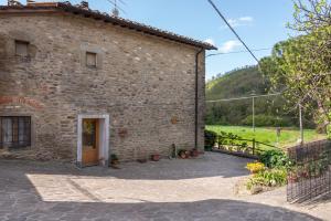 um edifício de pedra com uma porta e um quintal em Agriturismo Il Ponte em Vicchio