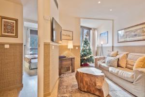 a living room with a couch and a christmas tree at Luderna - Apartamento Dera Nhèu in Baqueira-Beret