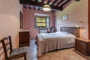 um quarto com uma cama, uma cadeira e uma janela em Agriturismo Il Ponte em Vicchio