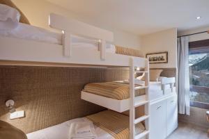 two bunk beds in a room with a window at Luderna - Apartamento Dera Nhèu in Baqueira-Beret