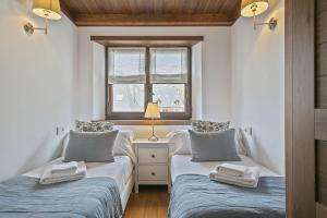 2 łóżka pojedyncze w pokoju z oknem w obiekcie Luderna - Apartamento Val de Ruda B14 Paulet w mieście Baqueira-Beret