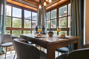 uma sala de jantar com uma mesa com copos de vinho em Luderna - Apartamento Val de Ruda B21 Blanhiblar em Baqueira-Beret
