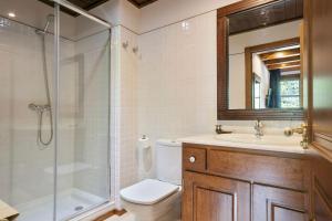 een badkamer met een douche, een toilet en een wastafel bij Luderna - Apartamento Val de Ruda B21 Blanhiblar in Baqueira-Beret