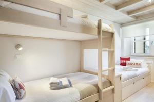 two bunk beds in a small room with a window at Luderna - Apartamento Val de Ruda B26 des Garonets in Baqueira-Beret