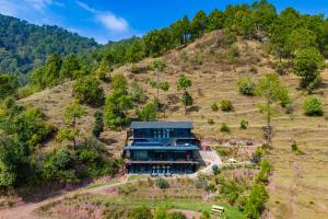 an aerial view of a house on a hill at StayVista at Leopard's Creek with Pool in Solan +30 photos
