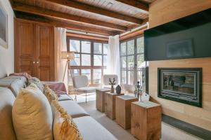 Una sala de estar con un sofá y una chimenea. en Luderna - Apartamento Val de Ruda B3 Entecada, en Baqueira Beret