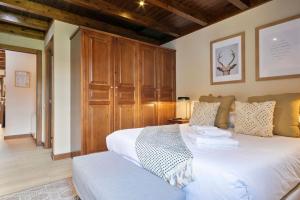 a bedroom with a large white bed and wooden cabinets at Luderna - Apartamento Val de Ruda B3 Entecada in Baqueira-Beret