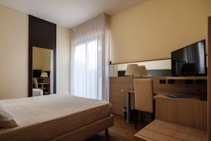 里乔内Augustus Hotel Riccione的配有床和电视的酒店房间