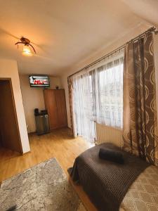a bedroom with a bed and a window with a television at Czarne jagody in Kościelisko