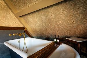 a bath tub in a bathroom with wallpaper at Old Town Luxury, By The Sea in Scarborough