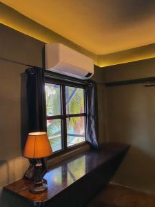 a lamp sitting on a table next to a window at Mojo Hostel in Puerto Princesa City