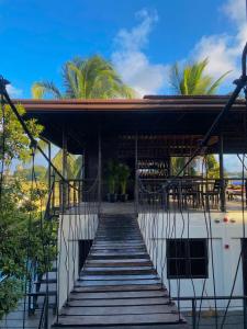 a wooden staircase leading to a building with palm trees at Mojo Hostel in Puerto Princesa City