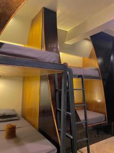 a group of bunk beds in a room with a ladder at Mojo Hostel in Puerto Princesa City