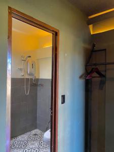 a bathroom with a shower and a toilet in it at Mojo Hostel in Puerto Princesa City