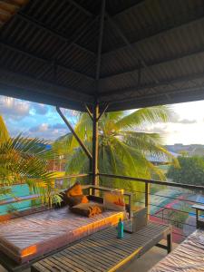 eine Bank auf einer Veranda mit Meerblick in der Unterkunft Mojo Hostel in Puerto Princesa