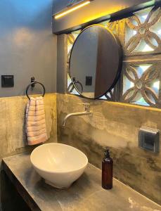 ein Bad mit einem Waschbecken und einem Spiegel in der Unterkunft Mojo Hostel in Puerto Princesa