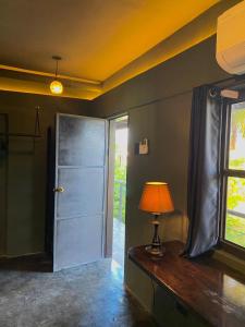 a room with a door and a lamp on a table at Mojo Hostel in Puerto Princesa City