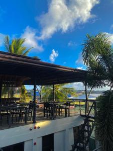 um restaurante com mesas e palmeiras na praia em Mojo Hostel em Puerto Princesa