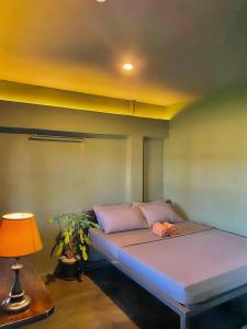 a bed in a room with a lamp and a bed sidx sidx sidx at Mojo Hostel in Puerto Princesa City