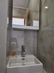 a bathroom with a white sink and a mirror at Christina Studios in Kefalos