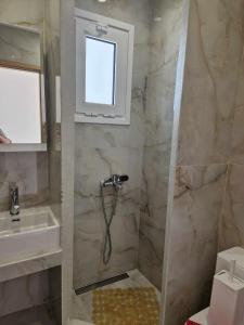 ein Bad mit einer Dusche und einem Waschbecken in der Unterkunft Christina Studios in Kefalos