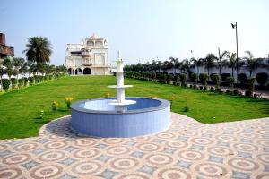 uma fonte no meio de um parque com um edifício em Vatika Banquet And Lawn em Gaya