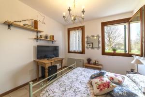 a bedroom with a bed and a flat screen tv at Agriturismo Al Botteniga in Treviso