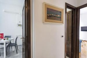 um quarto com uma mesa e um quadro na parede em Charming Family Apartment by Wonderful Italy em Gênova