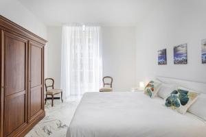 um quarto branco com uma cama grande e uma janela em Charming Family Apartment by Wonderful Italy em Gênova