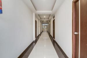 海得拉巴的住宿－Mr Dwell Hotel，白色墙壁和地板的办公楼里空无一人的走廊