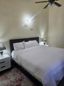 ファルマスにあるStonebrook Villaのベッドルーム1室(白いベッド1台、天井ファン付)