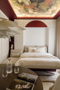 a bedroom with a large bed with a painting on the ceiling at ROUGE Studio in Bucharest in Bucharest