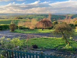 uma vista para um campo com árvores e uma cerca em Bryntirion Farmhouse Rooms (with bathroom) em Llanfair Caereinion