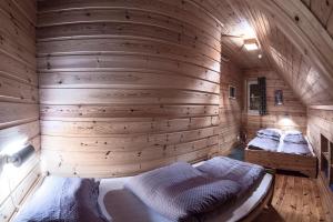a bedroom with two beds in a wooden wall at Knaben Utleie 