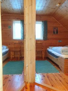 a room with two beds in a log cabin at Knaben Utleie 
