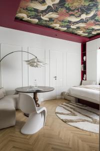a bedroom with a table and a large painting on the ceiling at ROUGE Studio in Bucharest in Bucharest +26 photos