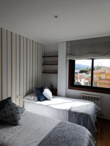 um quarto com 2 camas e uma janela em Apartamento en Poio-Pontevedra em Poio