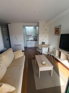 un soggiorno con divano bianco e tavolo di Apartamento en Poio-Pontevedra a Poio
